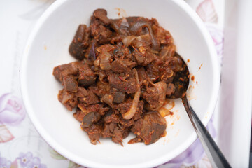 A picture of a locally prepared dish made up of spicy peppered goat known as Asun