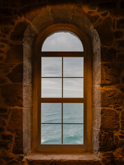Window of an old lighthouse, view over the ocean. San Vicente de la Barquera, Cantabria, Spain