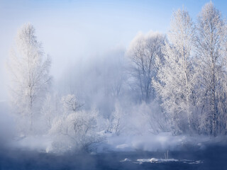 Fabulous winter landscape on the river. Fog. Trees in hoarfrost. Bright winter sunny day. Winter in...