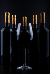 wine bottles and glass with black background