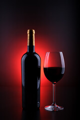 wine bottle with full glass black background and red