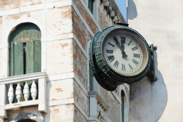 Fototapeta na wymiar Vintage clock hanging outside on the corner of the house