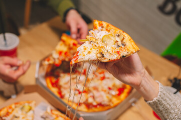 The guy and the girl eat pizza and drink a drink.