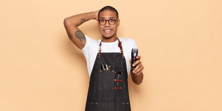young black man feeling stressed, worried, anxious or scared, with hands on head, panicking at mistake