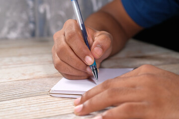 Close up of man hand writing on notepad.