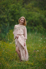 Fototapeta premium beautiful girl walking in a blooming field