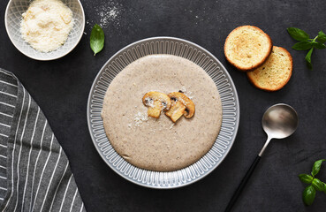 Soup puree with mushrooms and cheese on a concrete background. View from above.