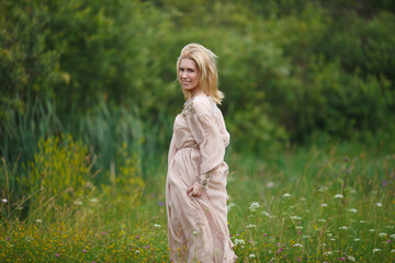 beautiful girl walking in a blooming field