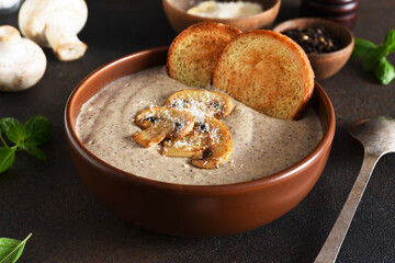 Soup puree with mushrooms and cheese on a concrete background.
