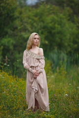 Fototapeta premium beautiful girl walking in a blooming field