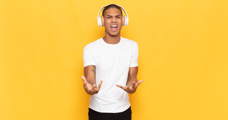 young black man looking angry, annoyed and frustrated screaming wtf or what’s wrong with you