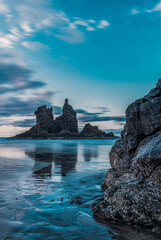 Paisaje de una playa con rocas en el atardecer