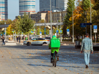 Food delivery. A cyclist delivers food on the autumn street in Moscow.