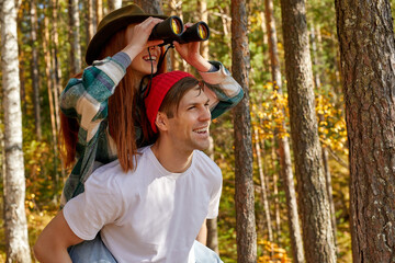 young caucasian sportive couple on trip in mountains. hike together, active autumn holidays, use binoculars for better contemplation