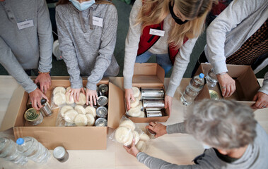 Top view of group of volunteers in community donation center, food bank and coronavirus concept.