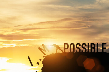 Businessman push impossible wording to possible wording on top of mountain with sunlight. Positive...