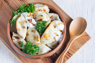 A bowl of russian varenyky, vareniki, Dumplings served with fried onion. Pyrohy - dumplings with filling. View from above, top, overhead. Close-up