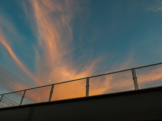 【街並み】高架橋の下からみた夕方の雲と空　背景素材
