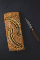Homemade banana nut bread loaf isolated on the dark background. Table top view and copy space.