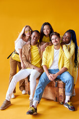 Obraz premium diversity, race, ethnicity and people concept. international group of happy friendly smiling men and women isolated on yellow background, studio shoot