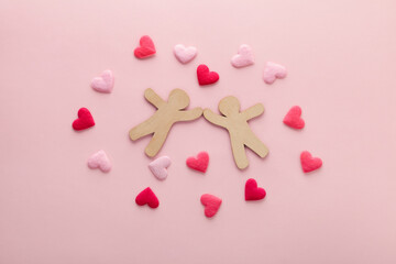 wooden couple with red hearts on pink background as symbol of love, top view, creative Valentine's day card and concept