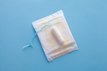 menstruation cycle, feminine hygiene and protection, sanitary pad and tampon on blue background, top view, flat layout, copy space for text
