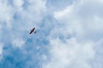 An airplane in the blue sky with beautiful clouds makes aerobatics.