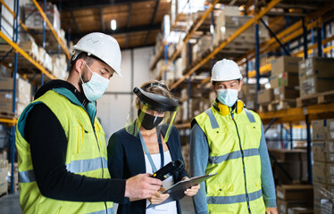 Fototapeta na wymiar Group of workers with manager working indoors in warehouse, coronavirus concept.