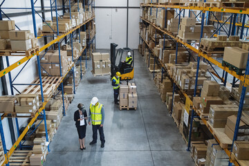 Top view of group of workers with manager indoors in warehouse, coronavirus concept. © Halfpoint