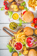 Bbq with hamburgers french fries. Homemade different meat burgers and hamburgers, with fryed potato and various sauces, white wooden table background