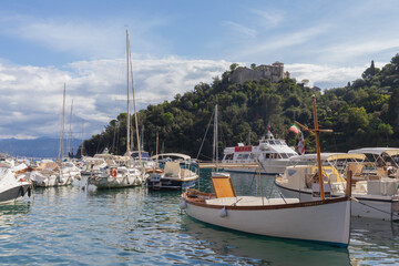Fototapeta na wymiar Boats in the Portofino harbor against cloudy sky, Italy