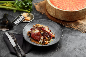 A plate of salad with beef roast beef, onions, arugula, pepper and tomatoes on a black table. Top view.