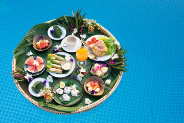 Fototapeta na wymiar Breakfast tray in swimming pool, floating breakfast in luxury hotel