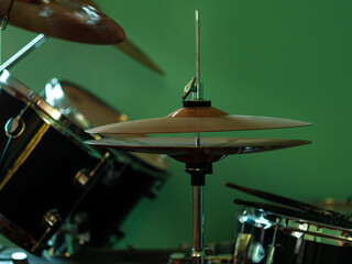 Fototapeta na wymiar Black drum kit close-up. Musician set with mix of drums in studio. Musical instruments devices for drumming performance. Low key, dark and moody rock metal music style. Selective focus on cymbals.