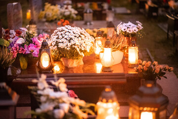 candles and white flowers on the tomb on All Saints' Day
 - obrazy, fototapety, plakaty