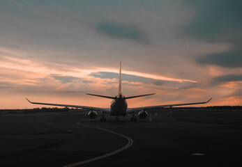 Fototapeta na wymiar Sunset view of an airoplane on airport runway under the dramatic sky in Prague. technology and world travel concept