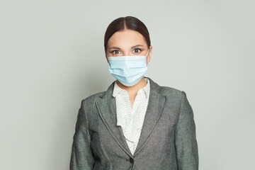 Confident woman in protective medical mask on white background