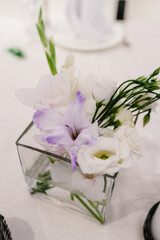 Obraz na płótnie Canvas Composition of violet, white flowers and greenery on table. Home decor. Wedding decoration.