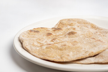 Flatbread on a white plate close-up on a white table