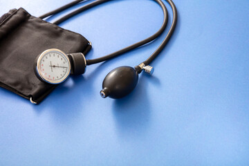 Medical sphygmomanometer on blue background, closeup view.