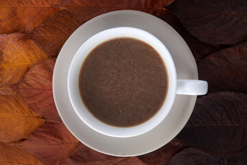 Cup of coffee with autumn leaves. Autumn decor, fall mood
