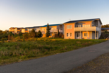 New detached houses in a housing development  warmly lit by a setting sun