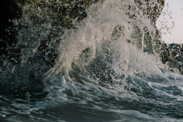 waves crashing against cliff 