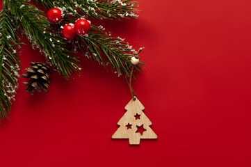 Wooden Christmas tree toy in the form of a Christmas tree on a red background.