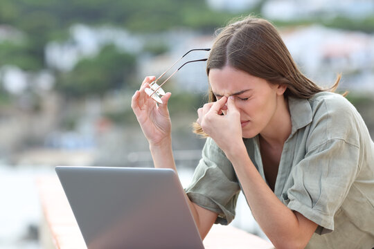 Woman Using Laptop Suffering Eyestrain In A Balcony