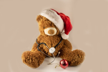 Plush teddy bear with stethoscope and Santa's hat