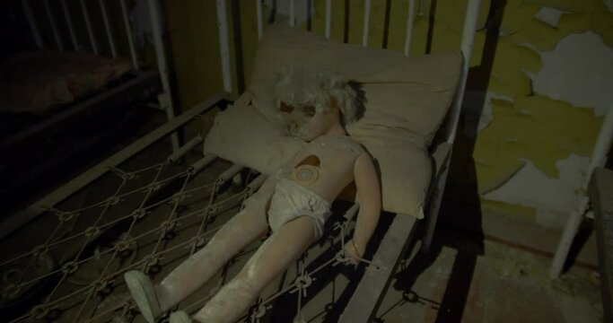An abandoned doll on a children's hospital bed in Chernobyl -mid shot