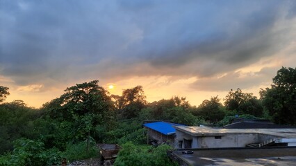 Fototapeta premium Indian village sunset scene above house roofs