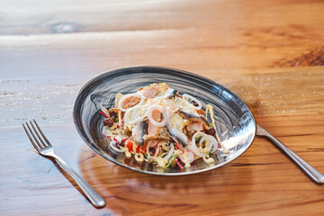 plate with fish salad herring a wooden table