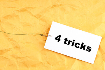 paper on a fishing hook with 4 tricks written on it